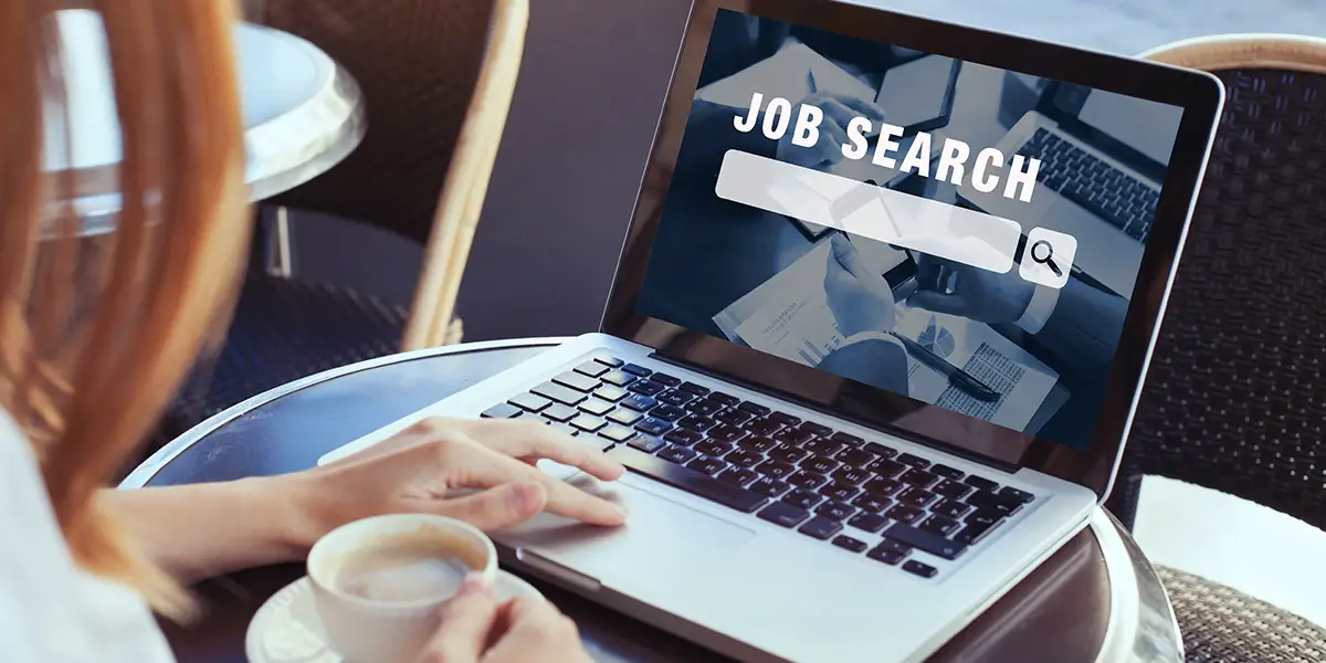 Online-Recruiting: Frau arbeitet an einem Computer, Fokus liegt auf dem Bildschirm mit der Schrift: Job Search